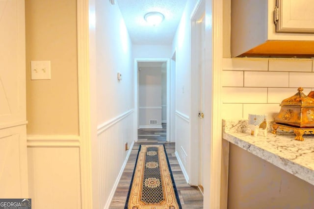 5293 Sandy Shoals Ln, Stone Mountain, GA 30087 - corridor with dark wood-style floors, a decorative wall, a wainscoted wall, and a textured ceiling