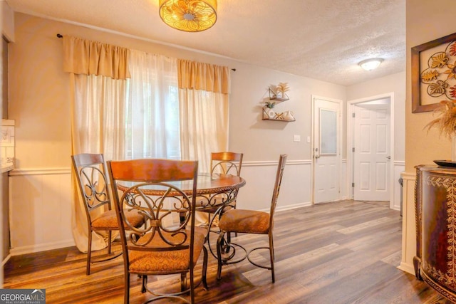 5293 Sandy Shoals Ln, Stone Mountain, GA 30087 - dining area featuring a textured ceiling, wood finished floors, and wainscoting