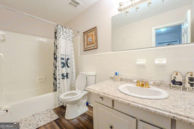 5293 Sandy Shoals Ln, Stone Mountain, GA 30087 - bathroom featuring toilet, wood finished floors, vanity, shower / bathtub combination with curtain, and tile walls