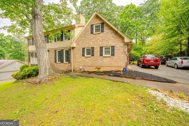5293 Sandy Shoals Ln, Stone Mountain, GA 30087 - view of front of home featuring brick siding, a chimney, a front lawn, and concrete driveway