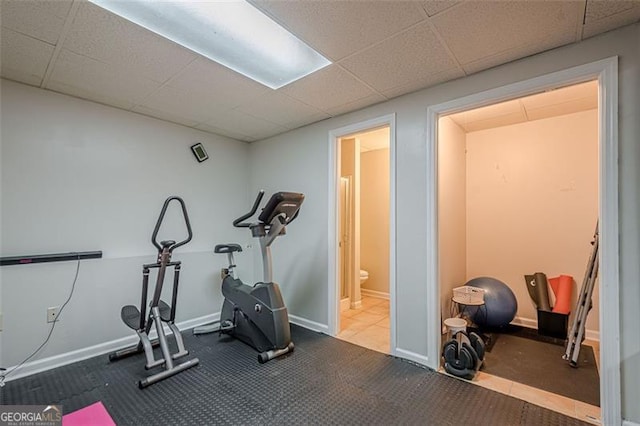 workout room with a drop ceiling and baseboards