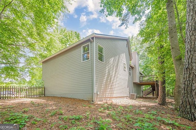 view of property exterior featuring stairway, a wooden deck, and central AC
