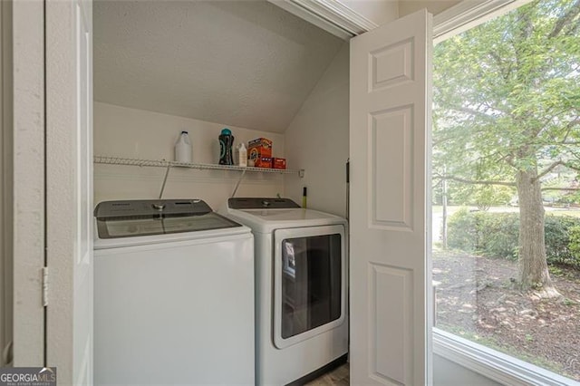 laundry area with separate washer and dryer and a textured ceiling