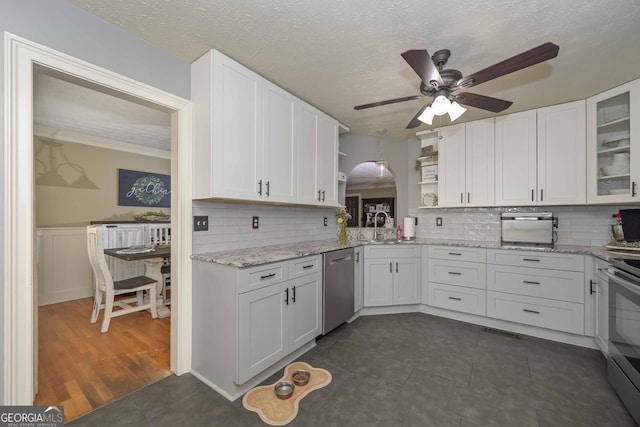 9001 E Carroll Rd, Winston, GA 30187 - kitchen featuring open shelves, appliances with stainless steel finishes, ceiling fan, white cabinetry, and arched walkways