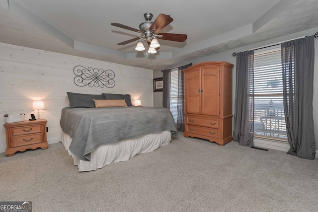 9001 E Carroll Rd, Winston, GA 30187 - bedroom featuring light carpet, a tray ceiling, a ceiling fan, and wood walls