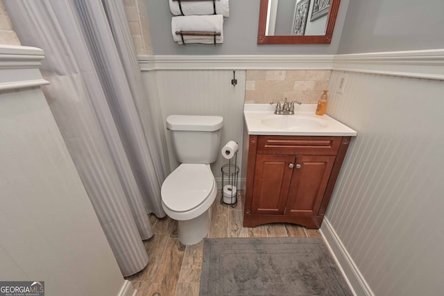 9001 E Carroll Rd, Winston, GA 30187 - bathroom with wood finished floors, a wainscoted wall, toilet, and vanity