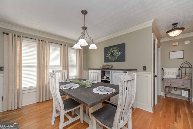 9001 E Carroll Rd, Winston, GA 30187 - dining room featuring plenty of natural light, light wood finished floors, ornamental molding, a chandelier, and a wainscoted wall