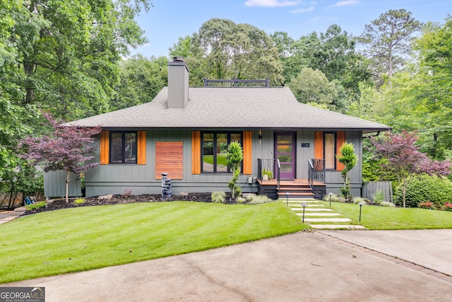 921 Oak Dr, Woodstock, GA 30189 - view of front facade featuring roof with shingles, a chimney, covered porch, and a front lawn