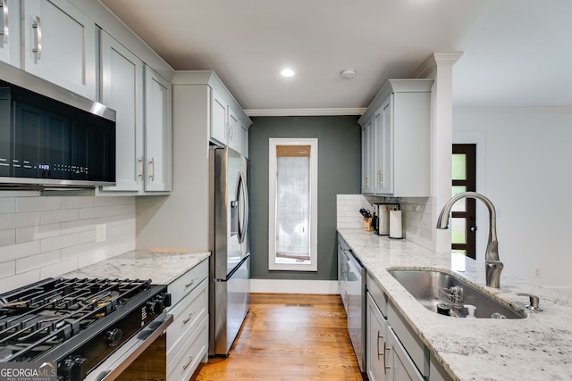 921 Oak Dr, Woodstock, GA 30189 - kitchen with stainless steel appliances, a sink, decorative backsplash, light stone countertops, and crown molding