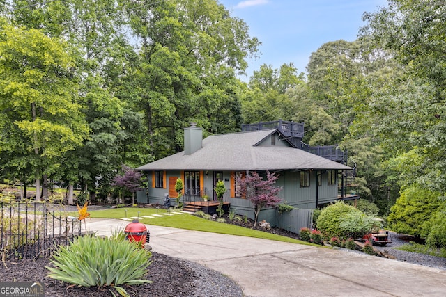 921 Oak Dr, Woodstock, GA 30189 - view of front of property featuring a chimney, covered porch, roof with shingles, and a front lawn
