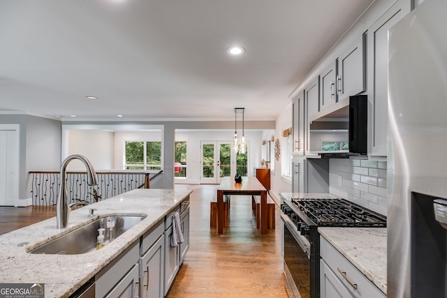 921 Oak Dr, Woodstock, GA 30189 - kitchen featuring appliances with stainless steel finishes, a sink, crown molding, light wood finished floors, and backsplash