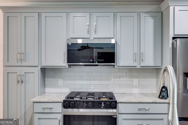 921 Oak Dr, Woodstock, GA 30189 - kitchen with appliances with stainless steel finishes, tasteful backsplash, light stone counters, and gray cabinets