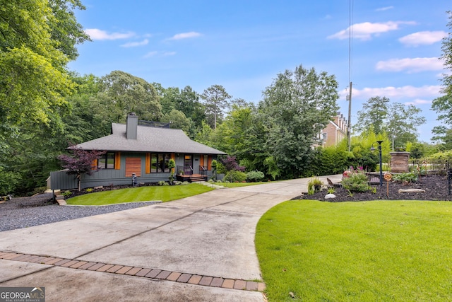 921 Oak Dr, Woodstock, GA 30189 - view of front of home with covered porch, a front lawn, driveway, a chimney, and a shingled roof