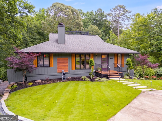 921 Oak Dr, Woodstock, GA 30189 - view of front facade with covered porch, a shingled roof, a front yard, and a chimney