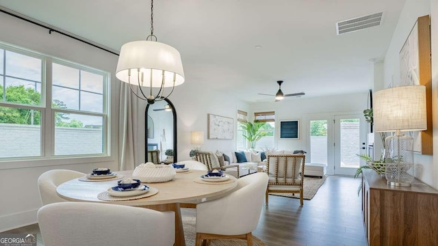 dining room with arched walkways, dark wood-type flooring, ceiling fan, and baseboards