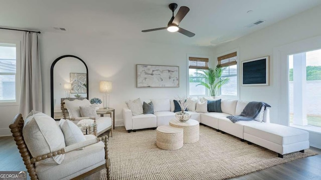 living room with wood finished floors, a ceiling fan, and baseboards