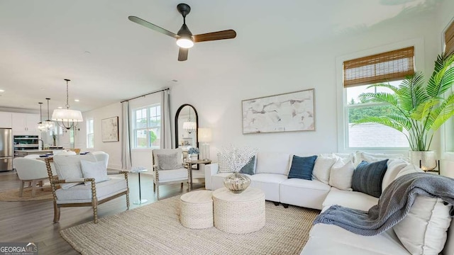 living area with ceiling fan, wood finished floors, recessed lighting, and a chandelier
