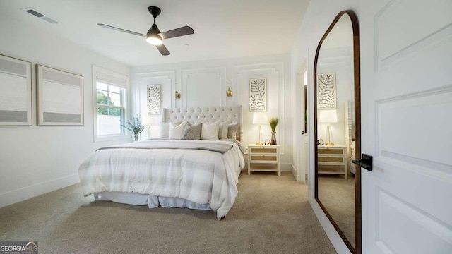 bedroom featuring light colored carpet, ceiling fan, and baseboards