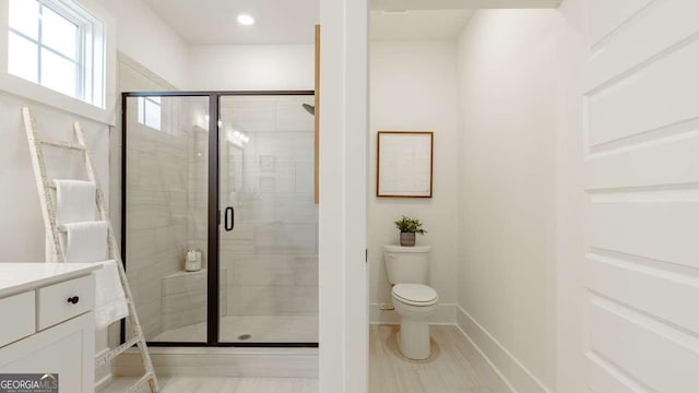 full bathroom with a shower stall, toilet, vanity, and baseboards