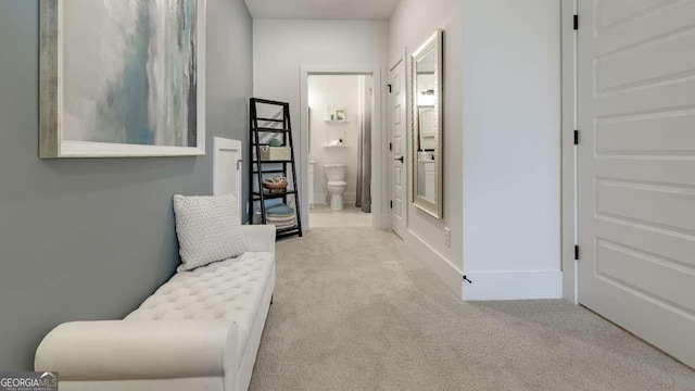 hallway featuring carpet and baseboards