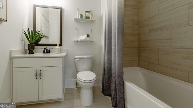 full bath featuring toilet, baseboards, vanity, and shower / bath combo