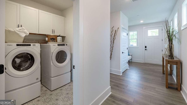 laundry area featuring washer and clothes dryer, cabinet space, baseboards, light wood finished floors, and recessed lighting