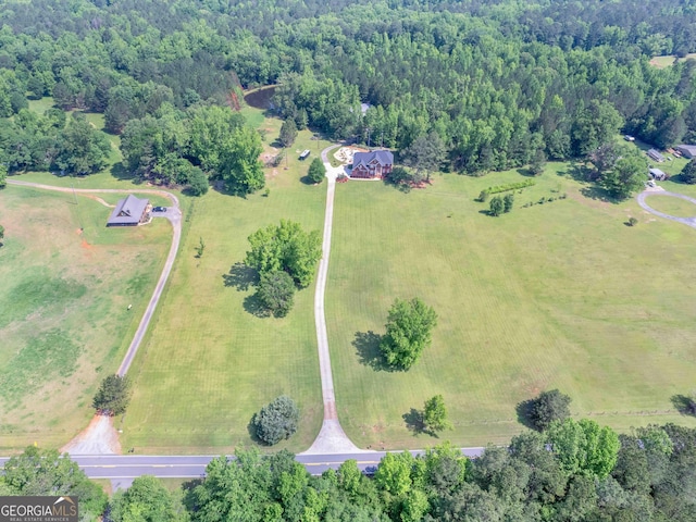 aerial view of property and surrounding area featuring a heavily wooded area