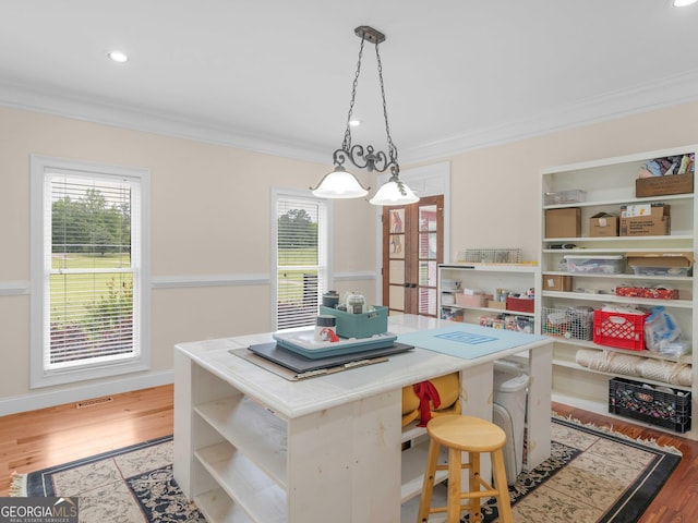 dining space with crown molding, healthy amount of natural light, wood finished floors, and recessed lighting