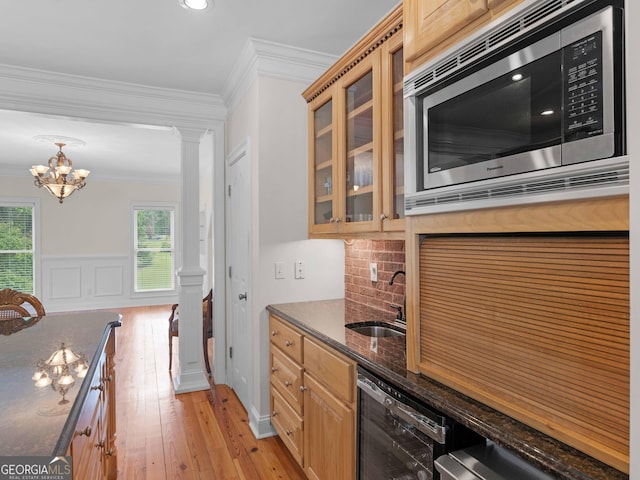 kitchen featuring stainless steel microwave, plenty of natural light, crown molding, light wood finished floors, and wine cooler