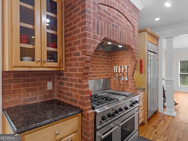kitchen featuring crown molding, premium appliances, backsplash, light wood-type flooring, and ventilation hood