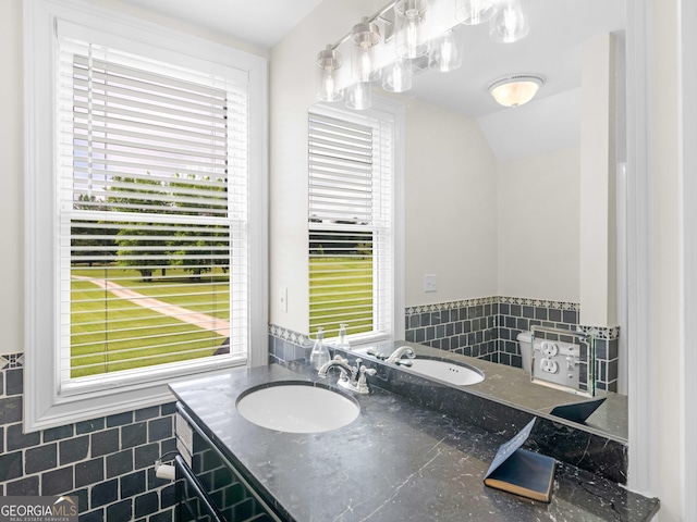 bathroom with plenty of natural light, lofted ceiling, vanity, and tile patterned flooring