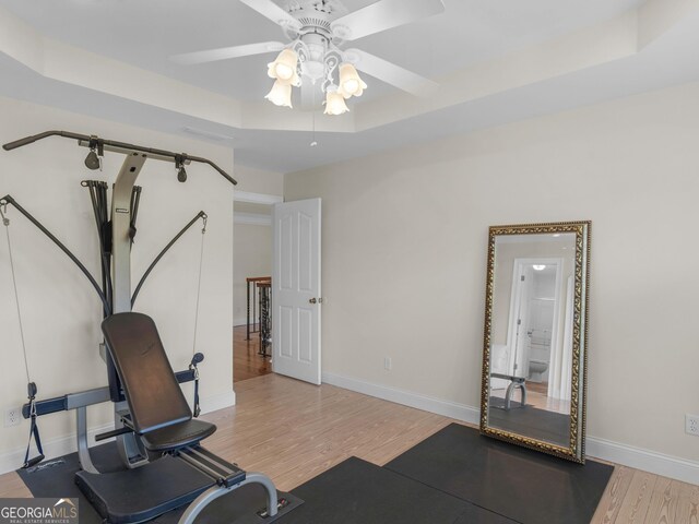 workout room with a ceiling fan, wood finished floors, and baseboards