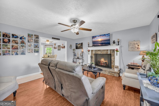 188 Mayapple Gln, Dawsonville, GA 30534 - living area with a ceiling fan, wood finished floors, a textured ceiling, and a stone fireplace