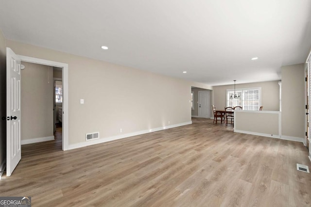 932 Mount Airy Dr SW, Atlanta, GA 30311 - unfurnished living room with baseboards, light wood-style floors, recessed lighting, and a chandelier