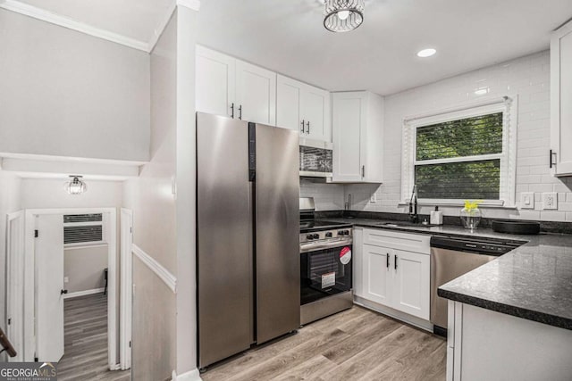 479 Charter Oak Dr SW, Atlanta, GA 30331 - kitchen with stainless steel appliances, dark countertops, light wood finished floors, white cabinetry, and crown molding