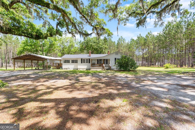 2445 Wilma Edwards Rd, Ellabell, GA 31308 - ranch-style home featuring a detached carport, dirt driveway, and a chimney