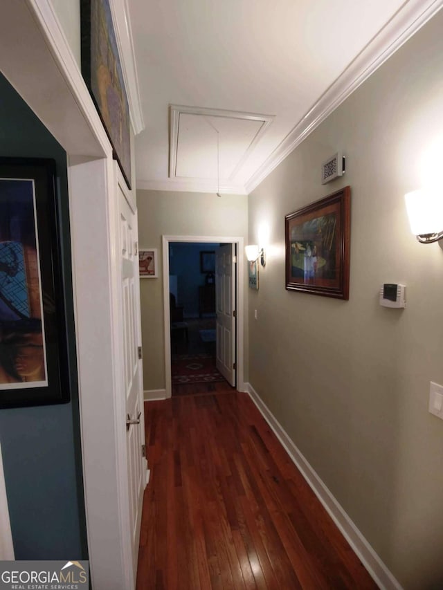 hall with attic access, dark wood-style floors, crown molding, and baseboards