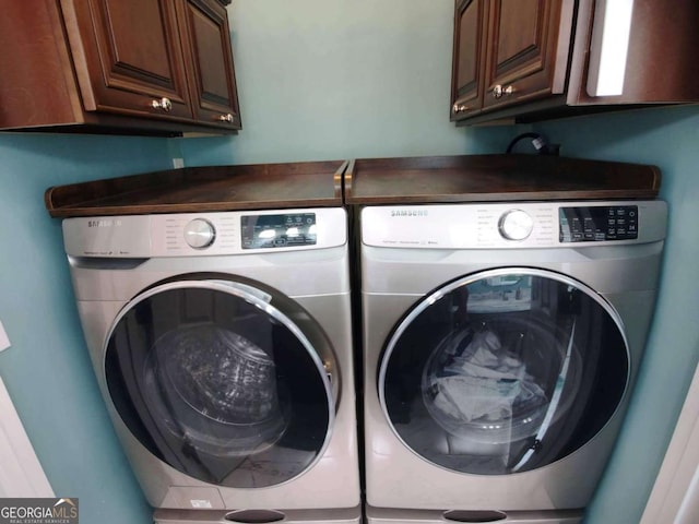 laundry room with washer and clothes dryer and cabinet space
