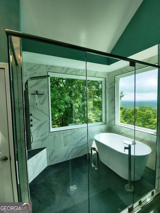 full bathroom with a stall shower, a soaking tub, and vaulted ceiling