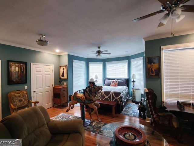 bedroom featuring wood finished floors, crown molding, and a ceiling fan