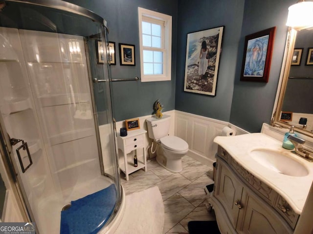 full bathroom with a shower stall, a wainscoted wall, marble look tile flooring, vanity, and toilet
