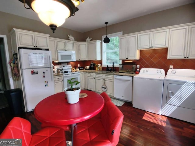 kitchen featuring white appliances, washing machine and dryer, dark wood-type flooring, and white cabinetry