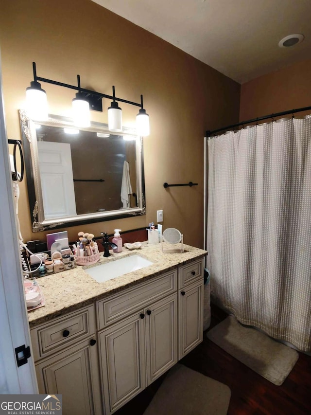full bathroom featuring wood finished floors and vanity