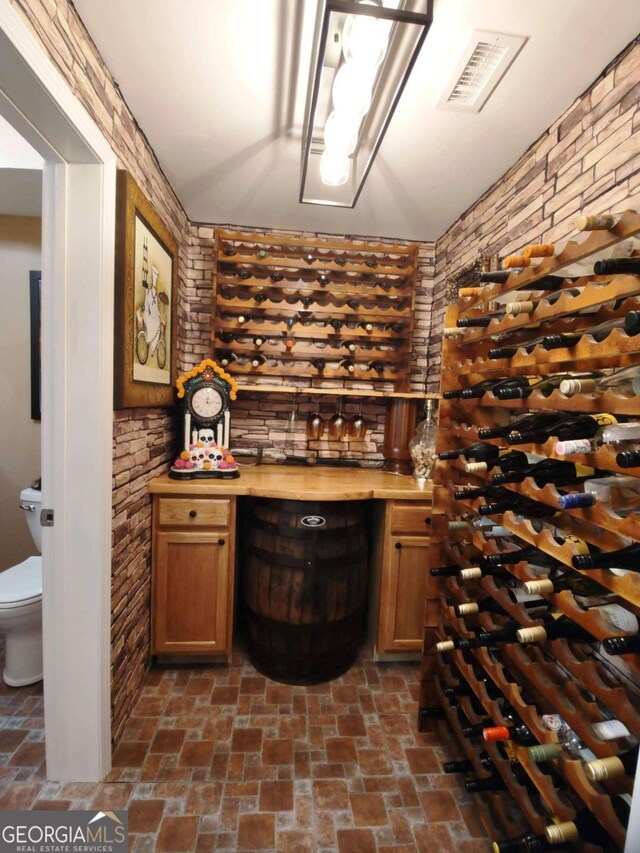 wine cellar featuring brick patterned floors