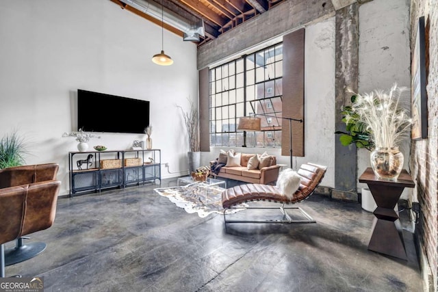 650 Glen Iris Dr NE Unit 27, Atlanta, GA 30308 - living area featuring a towering ceiling, finished concrete flooring, and beamed ceiling
