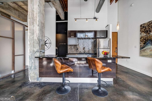 650 Glen Iris Dr NE Unit 27, Atlanta, GA 30308 - kitchen featuring a towering ceiling, freestanding refrigerator, tasteful backsplash, concrete floors, and dark countertops