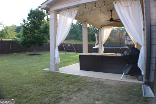 878 W Union Grove Cir, Auburn, GA 30011 - fenced backyard with a trampoline, ceiling fan, a patio, and outdoor lounge area