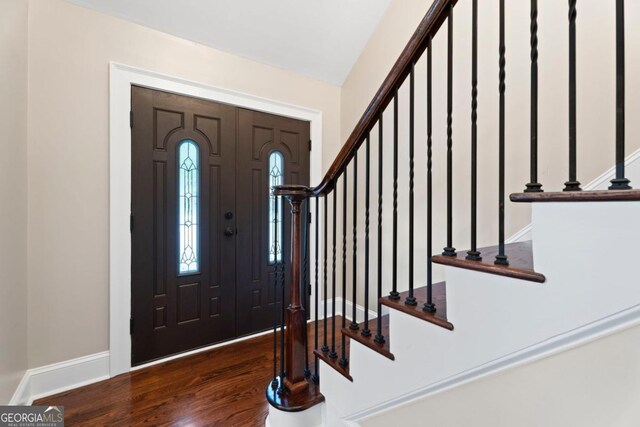 foyer with stairway, wood finished floors, and baseboards