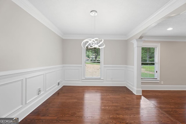 unfurnished dining area with healthy amount of natural light, a chandelier, a wainscoted wall, dark wood finished floors, and decorative columns