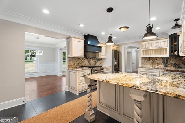 kitchen featuring custom exhaust hood, cream cabinetry, high end appliances, decorative backsplash, and recessed lighting